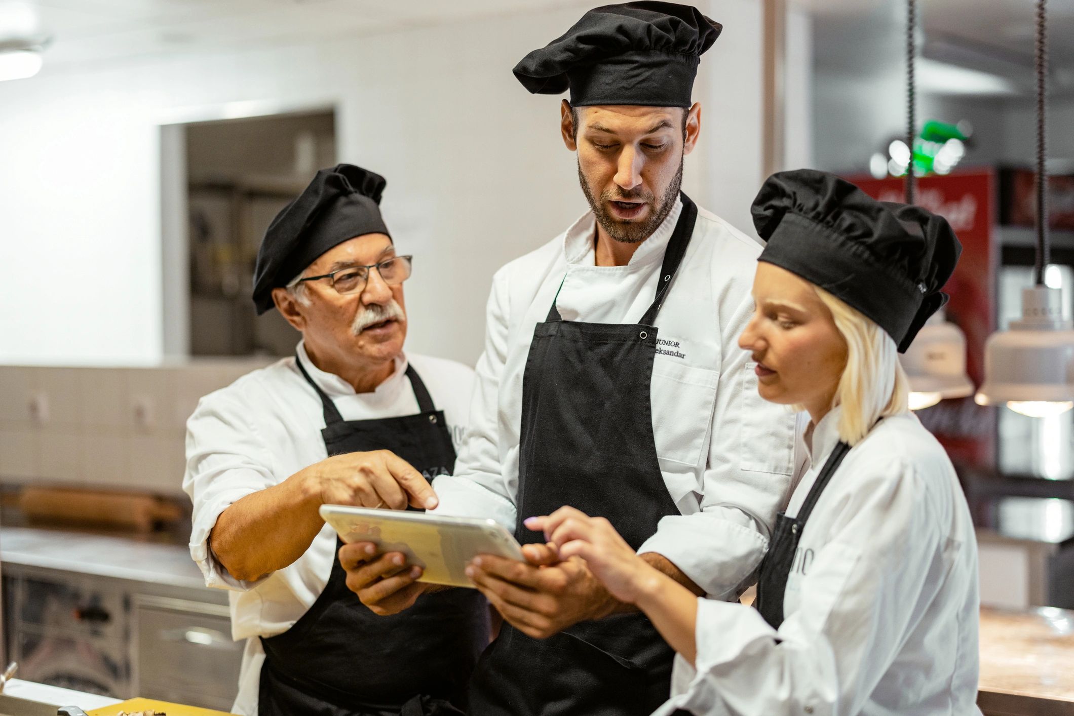 Chef using a tablet with kitchen staff