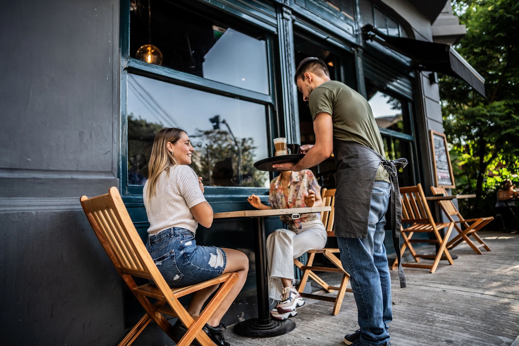 Waiter serving customers at a cafe