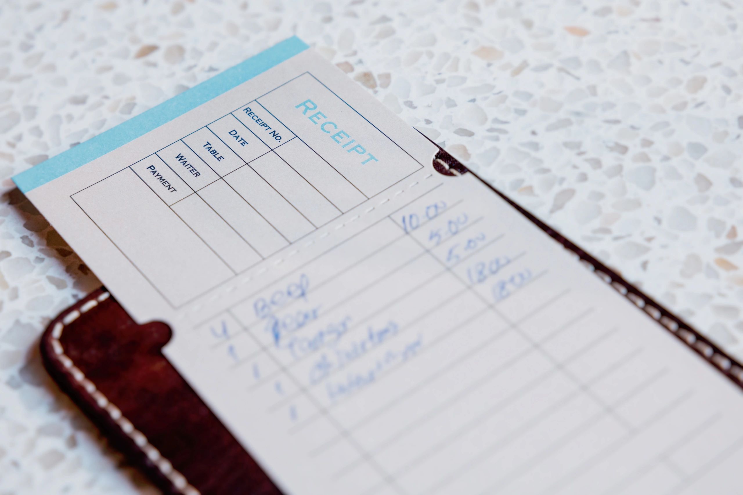 Restaurant bill in a wallet on a table, representing invoice payment