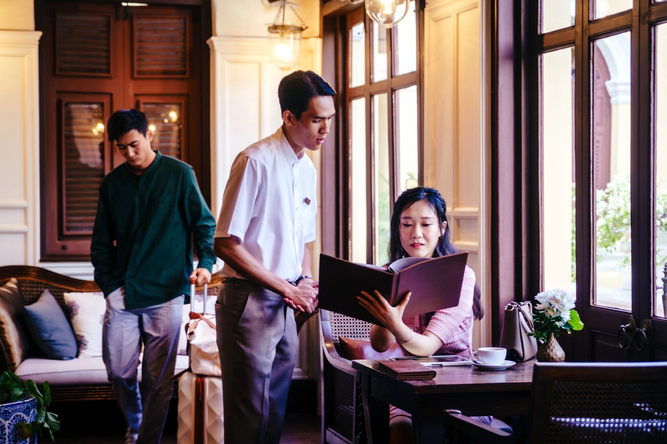Luxury villa staff taking a food order from guests at a hotel restaurant